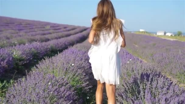 Mulher no campo de flores de lavanda ao pôr do sol em vestido branco e chapéu — Vídeo de Stock