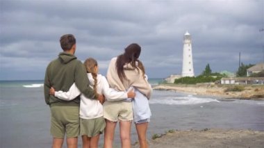 Dört kişilik aile deniz fenerine doğru yürür.