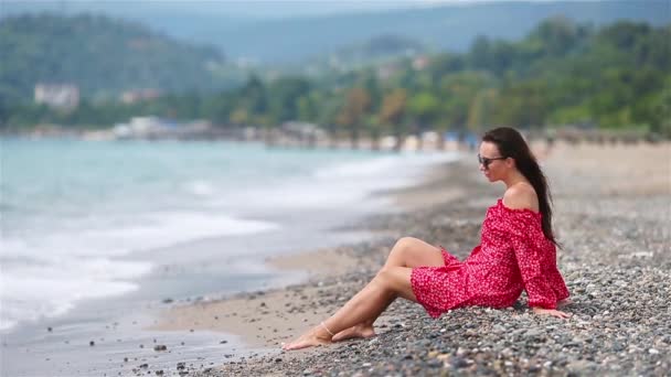 Jeune belle femme se détendre sur la plage — Video