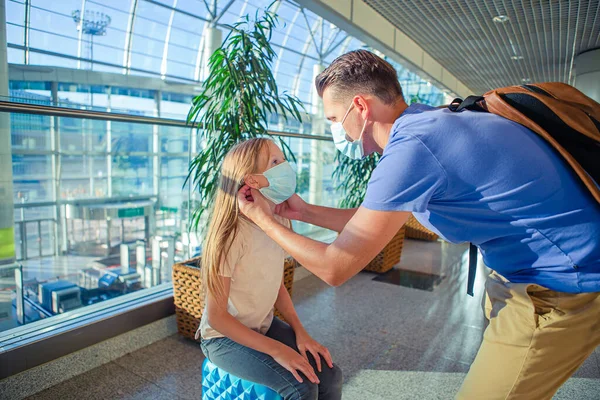 Táta a malá holka s nedickými maskami na letišti. Ochrana proti koronaviru a sevření — Stock fotografie