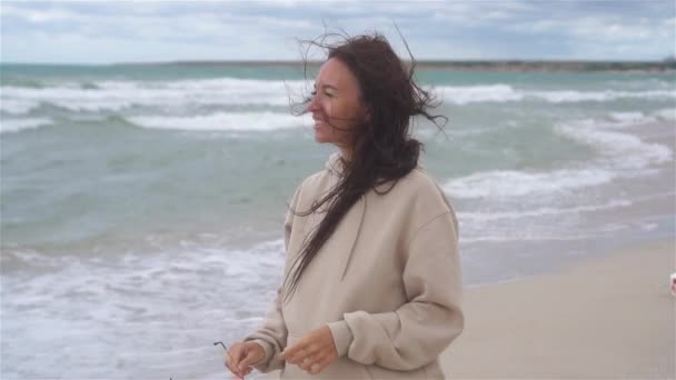 Jeune femme sur la plage dans la tempête — Video