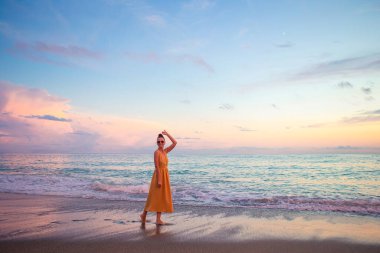 Plajda uzanan kadın yaz tatilinin tadını çıkarıyor ve denize bakıyor.