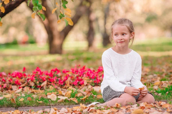 Portret uroczej dziewczynki z żółtymi i pomarańczowymi liśćmi bukiet na świeżym powietrzu w piękny jesienny dzień — Zdjęcie stockowe