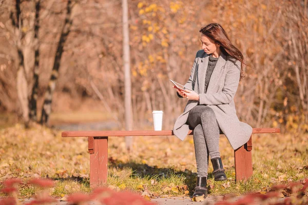 Concept d'automne - belle femme buvant du café dans le parc d'automne sous le feuillage d'automne — Photo