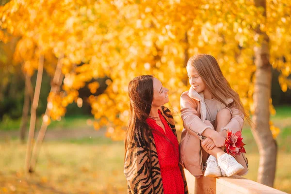 Little girl with mom outdoors in park at autumn day — Stock Photo, Image