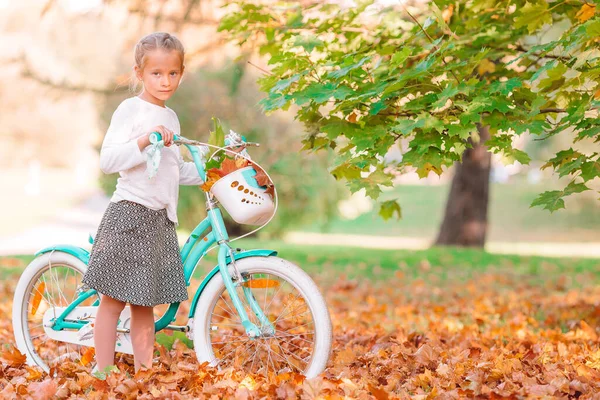 美しい秋の日に自転車に乗る愛らしい女の子屋外 — ストック写真