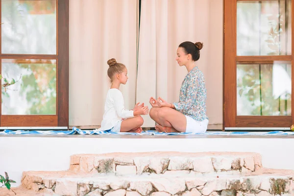 Happy young family meditating on the terrace — Stock Photo, Image