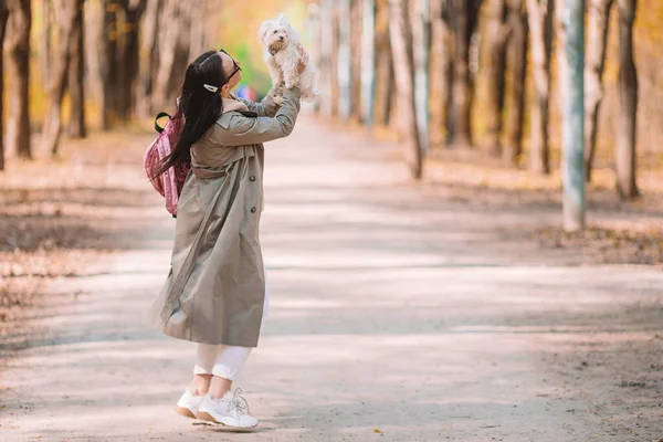 Giovane donna elegante a piedi con cane bianco — Foto Stock