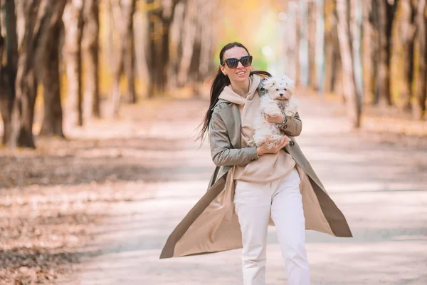 Junge stilvolle Frau geht mit weißem Hund spazieren — Stockfoto