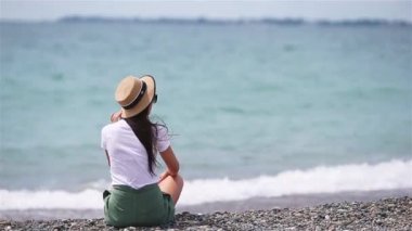 Plajda uzanan kadın yaz tatilinin tadını çıkarıyor ve denize bakıyor.