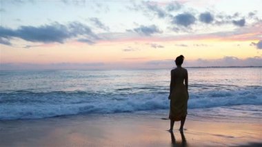 Plajda uzanan kadın yaz tatilinin tadını çıkarıyor ve denize bakıyor.