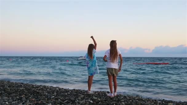 Små flickor har kul på tropiska stranden under sommarlovet — Stockvideo