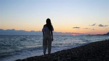 Plajda uzanan kadın yaz tatilinin tadını çıkarıyor ve denize bakıyor.