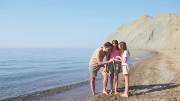 Família bonita feliz em umas férias de praia tropicais — Vídeo de Stock
