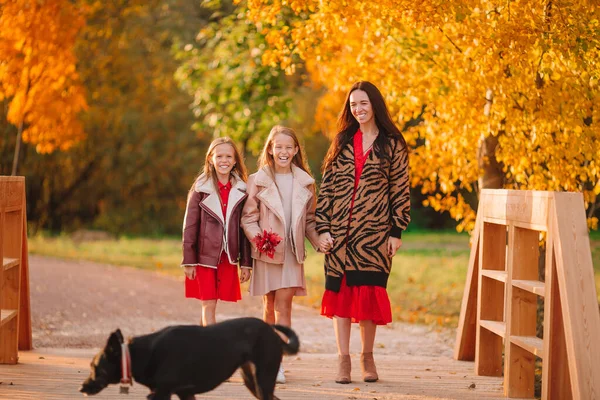 Little girls with mom outdoors in park at autumn day — Stock Photo, Image