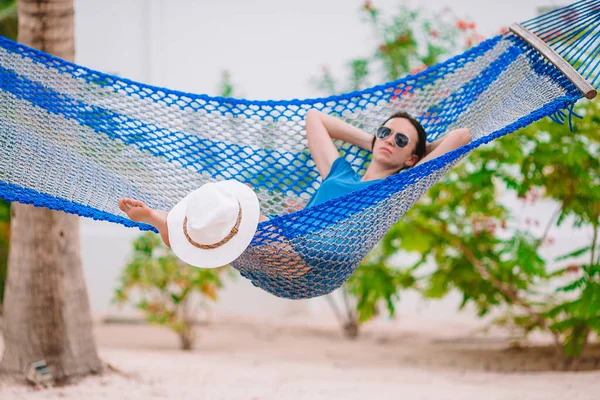 Tropikal tatildeki sevimli kız hamakta dinleniyor.