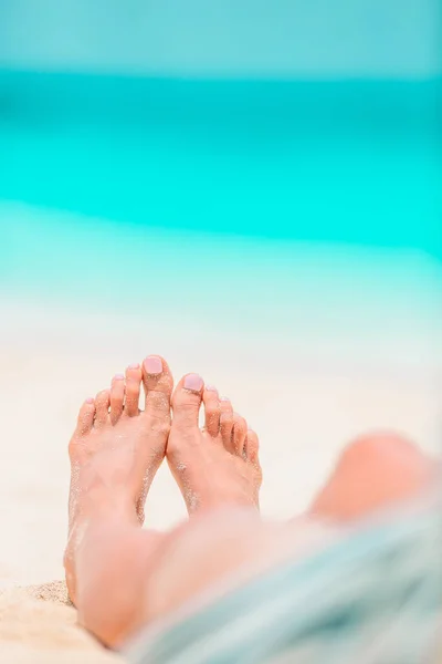 Γυναικεία πόδια στη λευκή αμμουδιά στα ρηχά νερά — Φωτογραφία Αρχείου