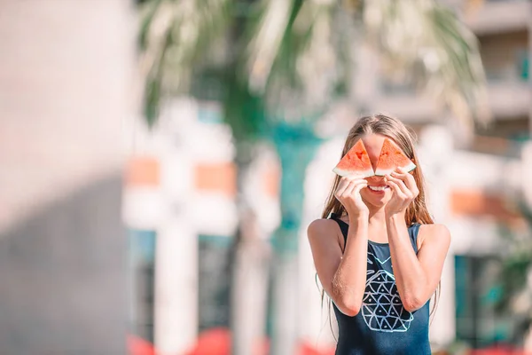 Κοριτσάκι που καλύπτει τα μάτια με πορτοκαλί ημίχρονα κοντά στα μάτια στην πισίνα υποβάθρου — Φωτογραφία Αρχείου