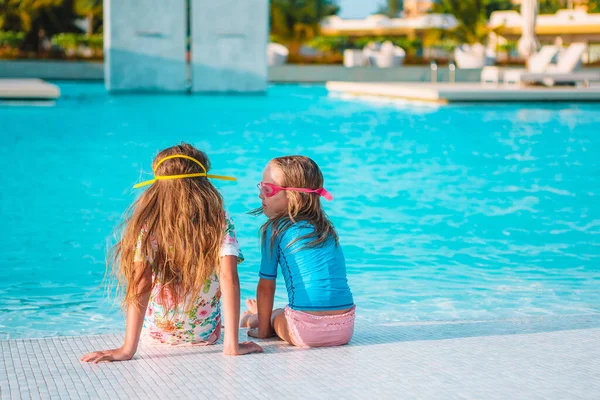 Rozkošné holčičky hrají ve venkovním bazénu na dovolenou — Stock fotografie