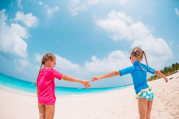 Little happy funny girls have a lot of fun at tropical beach playing together — Stock Photo, Image