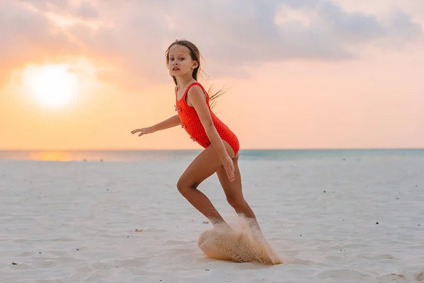 Adorabile bambina felice sulla spiaggia bianca al tramonto. — Foto Stock