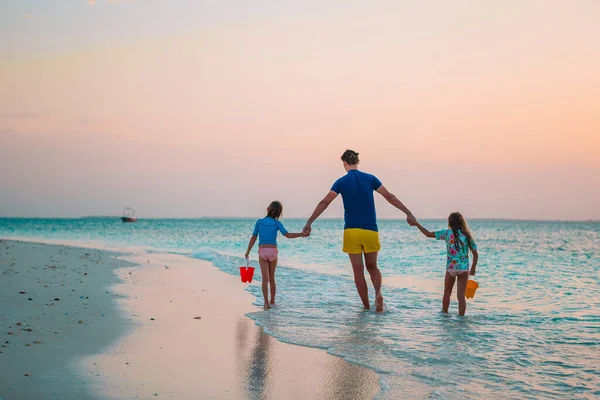 Lycklig far och hans söta små döttrar på tropiska stranden har kul — Stockfoto