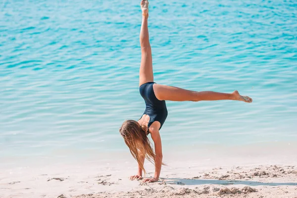 Schattig actief klein meisje aan het strand tijdens de zomervakantie — Stockfoto