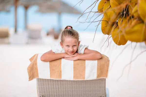 Malá rozkošná dívka v blízkosti kokosu na bílé tropické pláži — Stock fotografie