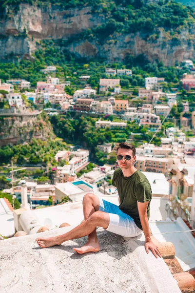 Sommarsemester i Italien. ung man i Positano byn på bakgrunden, Amalfikusten, Italien — Stockfoto