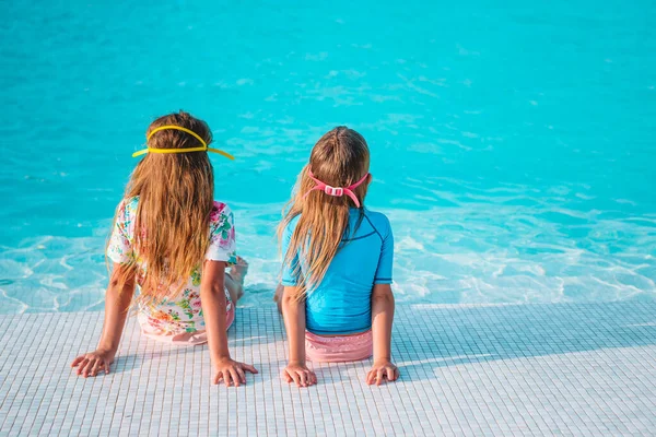 Adorables petites filles jouant dans la piscine extérieure en vacances — Photo