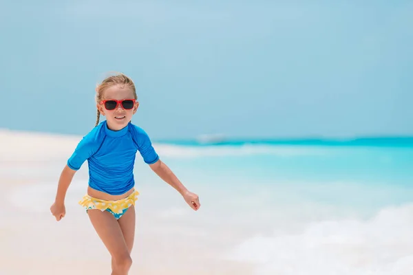 Schattig actief klein meisje aan het strand tijdens de zomervakantie — Stockfoto