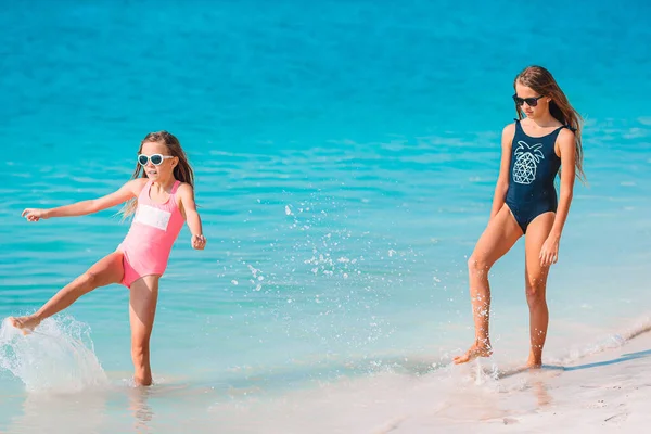 二人の小さな幸せな女の子は熱帯のビーチで一緒に遊んで楽しんでいます — ストック写真