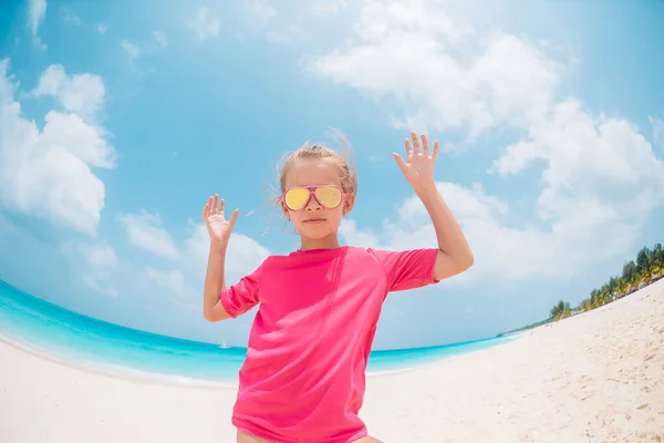 愛らしい女の子持っています楽しいです熱帯のビーチで休暇中 — ストック写真