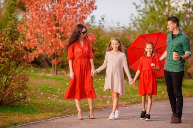 Sonbaharda dört kişilik mutlu bir ailenin portresi.