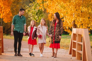 Sonbaharda dört kişilik mutlu bir ailenin portresi.