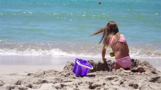 Κοριτσάκι σε τροπική λευκή παραλία κάνοντας κάστρο άμμο — Αρχείο Βίντεο