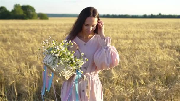 Vue arrière de la fille dans le champ de blé. Belle femme en robe avec du blé mûr dans les mains — Video