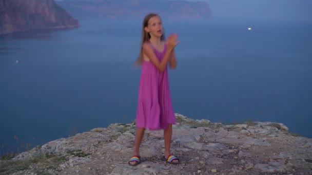 Niña en la cima de una montaña disfrutando de la vista del valle antes del atardecer — Vídeos de Stock