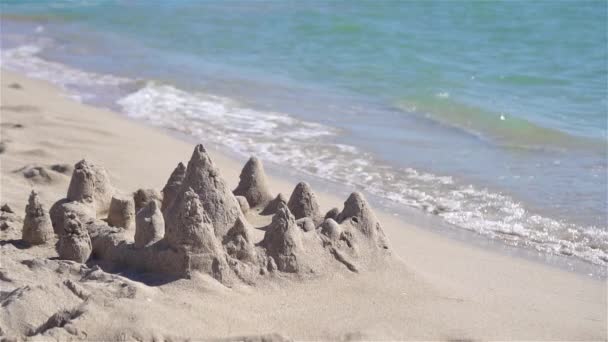 Castillo de arena en la playa tropical blanca con juguetes de plástico para niños — Vídeos de Stock