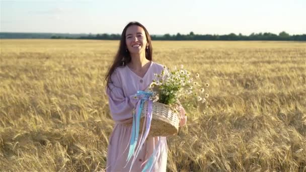 Vista posteriore della ragazza nel campo di grano. Bella donna in abito con grano maturo in mano — Video Stock