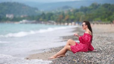 Plajda uzanan kadın yaz tatilinin tadını çıkarıyor ve denize bakıyor.