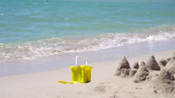 Sandcastle σε λευκή τροπική παραλία με πλαστικά παιδικά παιχνίδια — Αρχείο Βίντεο