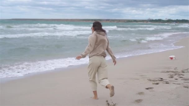 Junge Frau am Strand im Sturm — Stockvideo