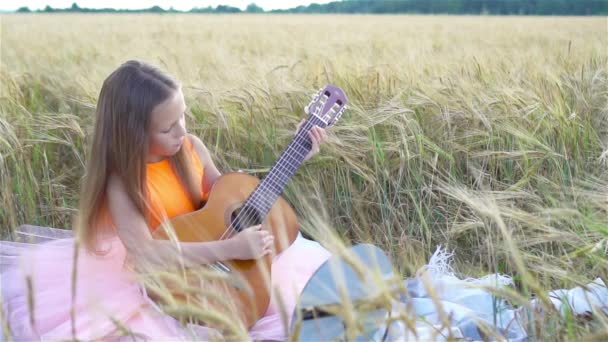 Liebenswertes Vorschulmädchen im Weizenfeld an einem warmen und sonnigen Sommertag — Stockvideo