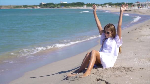 愛らしい女の子持っています楽しいです熱帯のビーチで休暇中 — ストック動画