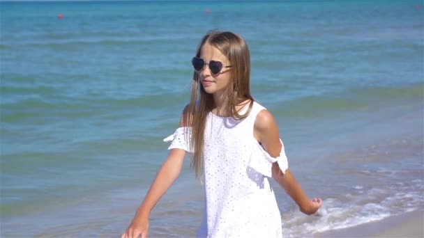 Schattig klein meisje veel plezier op tropisch strand tijdens vakantie — Stockvideo