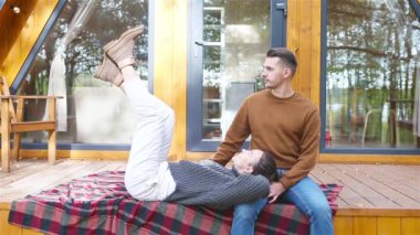 Genç çift sonbahar ormanında terasta oturuyor.