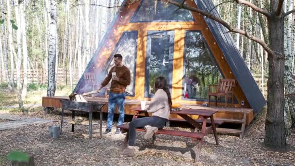 Young couple sitting on the terracein the autumn forest — Stock Video