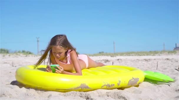 愛らしい女の子オンインフレータブル空気マットレスオンザビーチ — ストック動画