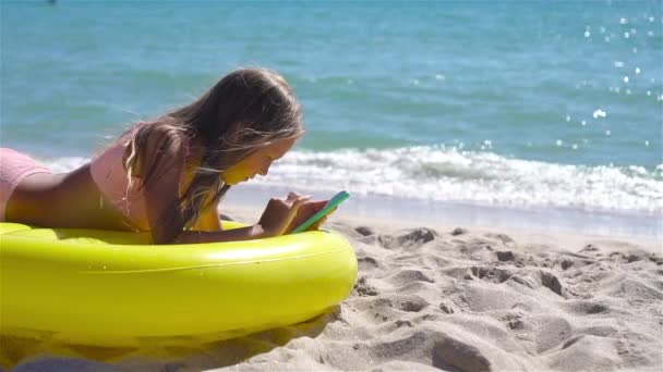해변에 있는 푹신 푹신 한 공기 매트리스에 앉아 있는 사랑 스러운 소녀 — 비디오